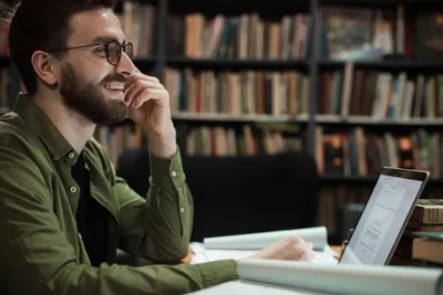 Person smiling whilst working on a laptop